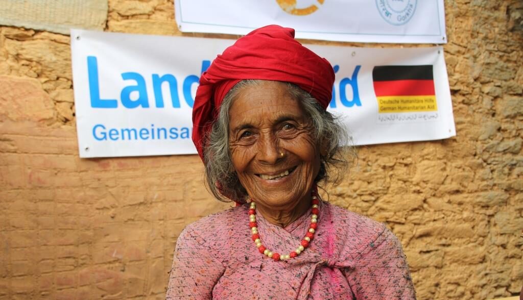 Alte Frau vor Landsaid logo