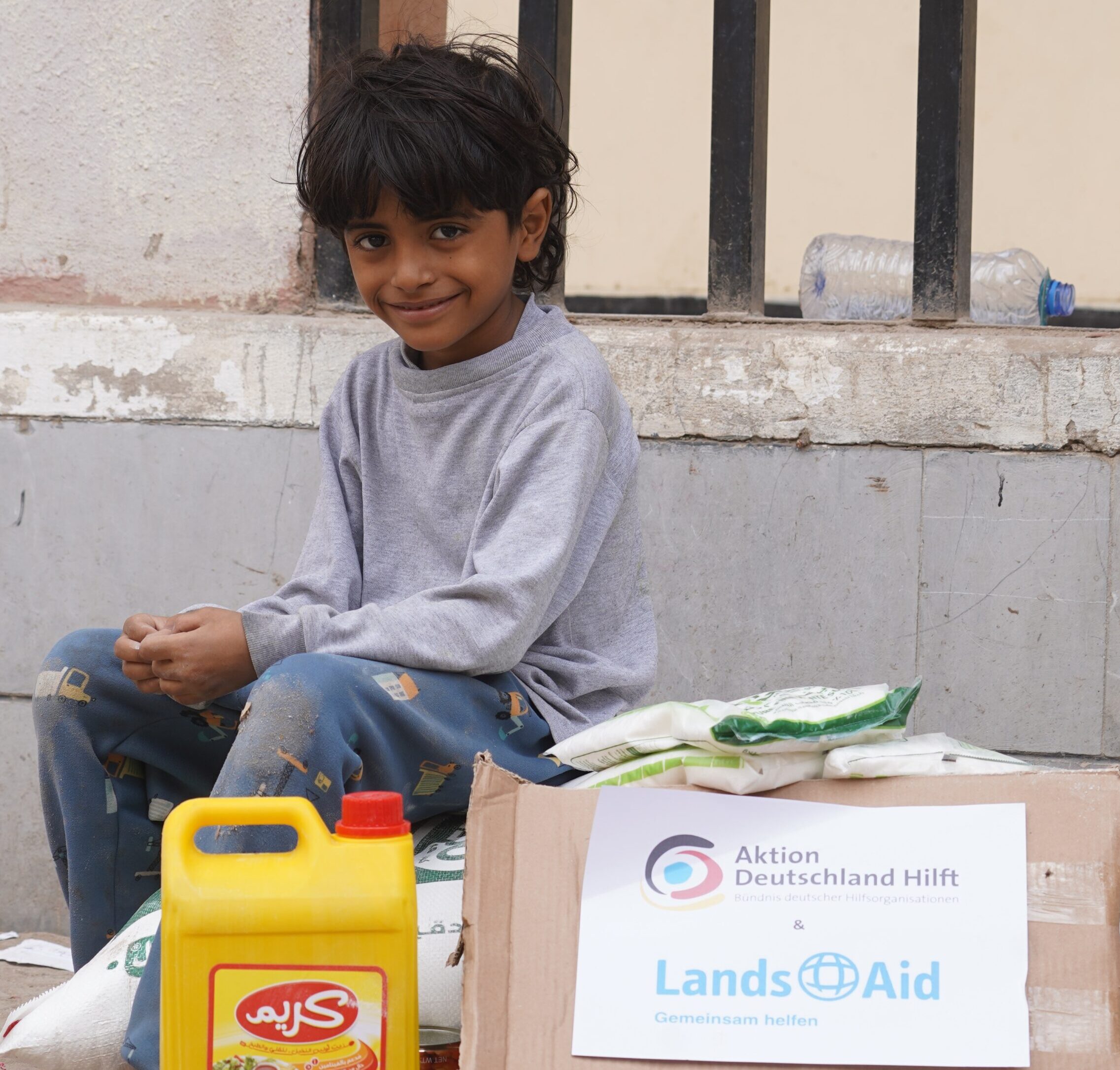 LandsAid_HND_Jemen_Junge vor Lebensmitteln
